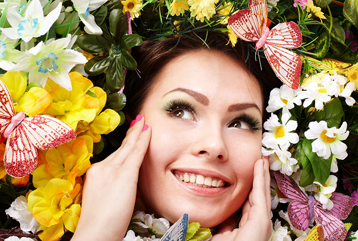Beautiful girl with butterfly and flower on grass. Outdoor.